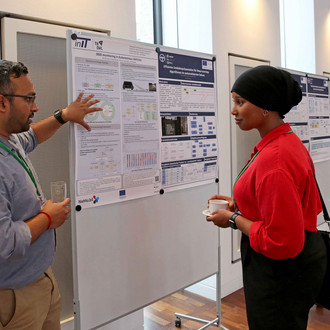 Ein Mann erklärt einer Frau sein wissenschaftliches Poster