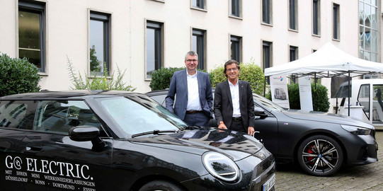 Zwei Personen stehen hinter Mini von BMW