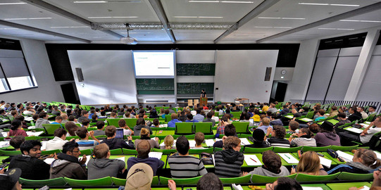 Students sit in a lecture hall in the seminar building at the Campus North.